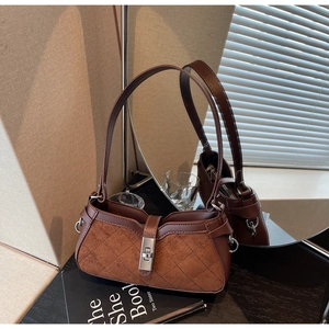 Dettaglio di cuciture a contrasto, patchwork in pelle scamosciata marrone e fibbia d'argento