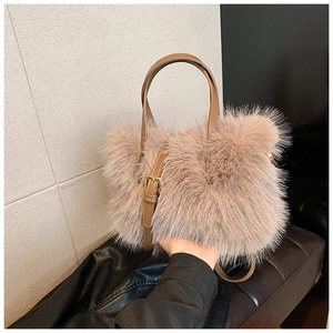 Detail of soft plush faux fur texture on a pink crossbody bag with leather handles