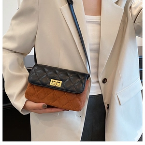 Detail of a quilted black leather flap and brown suede crossbody bag with gold hardware