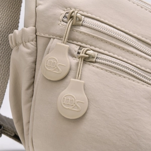 Makroaufnahme einer Nylon-Umhängetasche mit Doppelreißverschluss und Logo auf den Schiebern