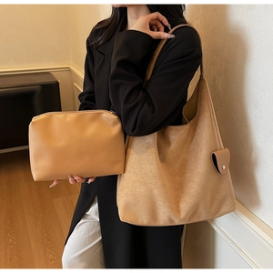 Close-up of brown faux suede tote bag and matching leather pouch worn by a model