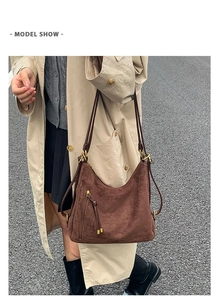 Deep brown frosted tote bag with fringe zippers shown on a model in street style