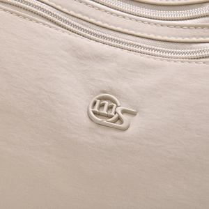 Nahaufnahme der hellbeige Nylontasche mit feiner Textur und mehreren Reißverschlüssen