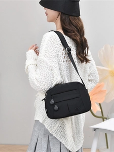 Versatile black nylon crossbody bag with multi-layer zippers and minimalist casual style