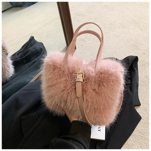 Detail of pink faux fur handbag showing thick fluffy texture and golden metal buckle strap