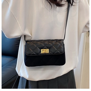 Detail of classic black quilted crossbody bag featuring a gold square twist lock clasp