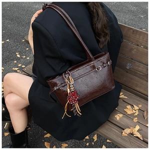 Close-up of retro brown oil wax leather tote bag with a leopard print flower charm