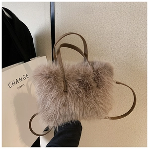 Detail of soft faux fur handbag featuring leather handles and matching shoulder strap