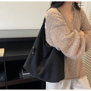 Detail of minimalist black faux suede tote bag with matte texture and slouchy design