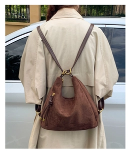 Detail of dark brown suede hobo bag showing versatile shoulder to backpack strap conversion