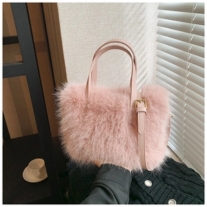 Detail of pink faux fur handbag showing golden hardware and soft plush texture