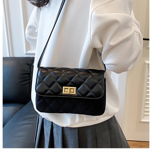 Close-up of black quilted crossbody bag showing leather texture and gold metal lock