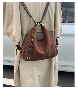 Detail of dark brown matte hobo bag with fringe tassel and bronze metal hardware