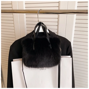 Close-up of soft black plush handbag texture with premium leather handle details