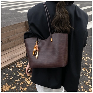 Détail du grand sac cabas marron foncé texturé avec pendentif pompon en bois vintage