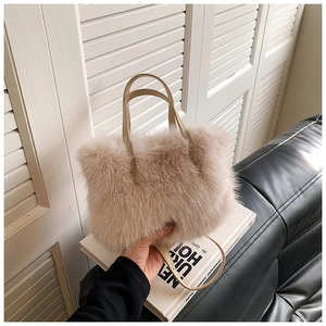 Detailed macro view of soft faux fur texture on the cream plush shoulder bag