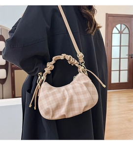 Detail of beige checkered crossbody bag with pleated cloud handle and gold hardware