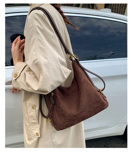 Detail of vintage brown suede hobo bag with tassel zipper and matte gold hardware