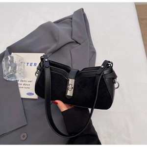 Detail of black saddle bag featuring frosted texture and silver metal twist lock closure