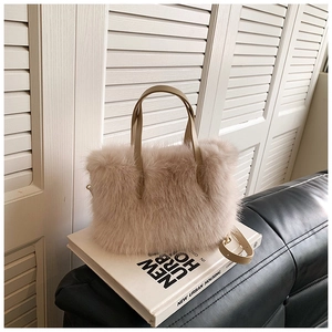 Detail of soft faux fur handbag in beige featuring adjustable leather strap and top handles