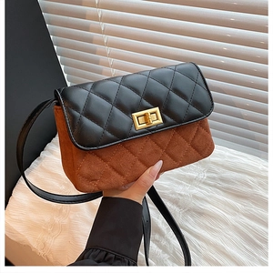 Detail of the stitching on the black leather flap and brown suede crossbody bag