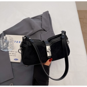Dettaglio della borsa in pelle scamosciata trapuntata nera con chiusura a scatto in metallo