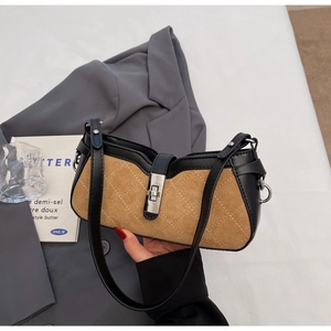Top-down view of a vintage brown suede saddle bag with black leather trim and silver lock