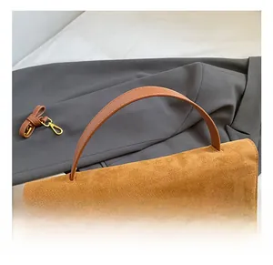 Detalle del asa cómoda de gamuza marrón mate y la correa del bolso retro multifunción