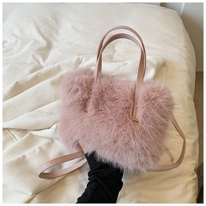 Detail of pink faux fur handbag with soft fluffy texture and matching leather shoulder strap