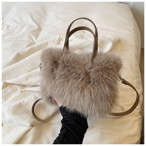 Detailed view of plush khaki faux fur handbag with premium leather handles and metal hardware