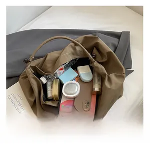 Intérieur spacieux d'un grand sac fourre-tout kaki avec poignées à perles et objets personnels