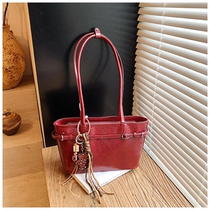 Close-up of glossy red patent leather tote bag with unique pleated texture and vintage charm