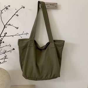 Detail view of large olive green canvas tote bag with sturdy long shoulder straps