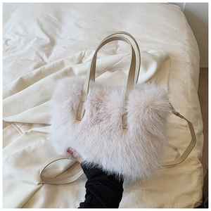 Detail of light pink faux fur handbag with soft texture and beige leather straps