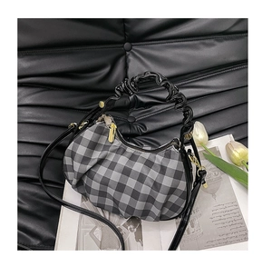 Detail of gingham pleated handbag with scrunchie handle and gold hardware accents