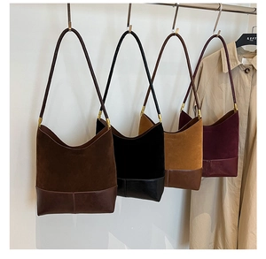 Close-up of four suede and leather bucket bags in brown, black, camel, and burgundy colors