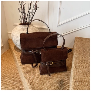 Detalle de mochilas vintage grandes y pequeñas en gamuza marrón sobre escalones de piedra