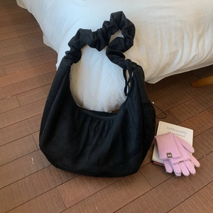 Close-up of black velvet hobo bag with unique ruched scrunchie shoulder strap design