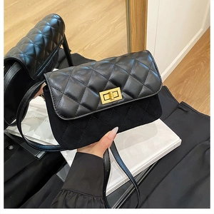 Detail of black quilted shoulder bag featuring gold twist lock and suede paneling