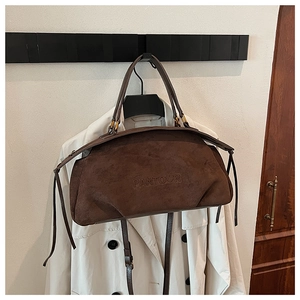 Detail of embossed PANTOOR logo on coffee brown suede leather tote bag with slim handles