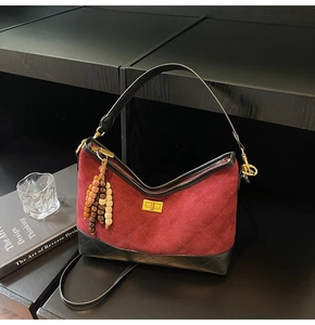 Detail of burgundy quilted suede shoulder bag with vintage wood bead tassel and metal lock