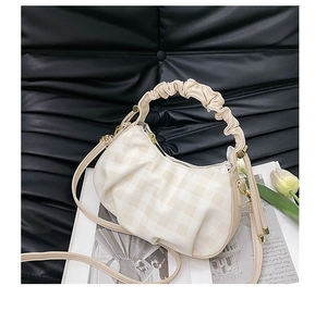 Detail of beige checkered boston bag with pleated cloud handle and golden hardware