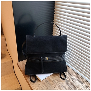 Vista detallada de mochila de cuero mate negro con hebilla dorada y detalles de correas