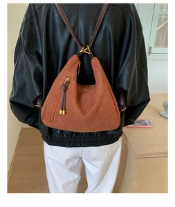 Detail of vintage brown suede hobo bag with leather tassel and adjustable straps