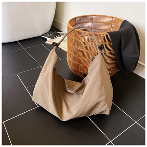 Gros plan d'un sac cabas kaki avec perles en bois et texture de tissu haute densité