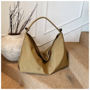 Détail du sac hobo en nylon kaki avec des perles en bois sur la bandoulière réglable