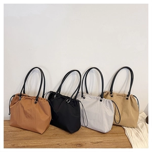 Detailed close-up of drawstring tote bags in brown, black, grey and khaki colors