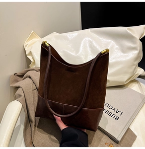 Détail du sac seau marron café en daim et cuir avec poignée supérieure élégante