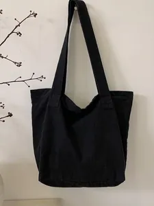 Minimalist black canvas tote bag with wide straps for casual commuting and daily shopping