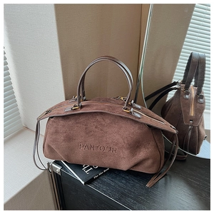 Detail showing deep brown suede texture and embossed logo on large tote bag